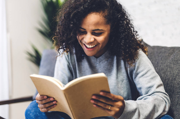Nuori afrikkalainen amerikkalainen musta nainen rentouttava ja lukeminen kirja
  - Valokuva, kuva