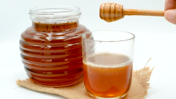 Close-up honing laten vallen met houten. Dipper in een glazen plaats op de zak. - Video