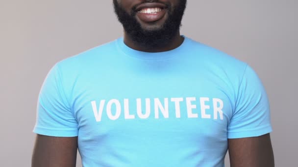 Smiling african american volunteer holding cardboard giftbox, assistance charity - Metraje, vídeo