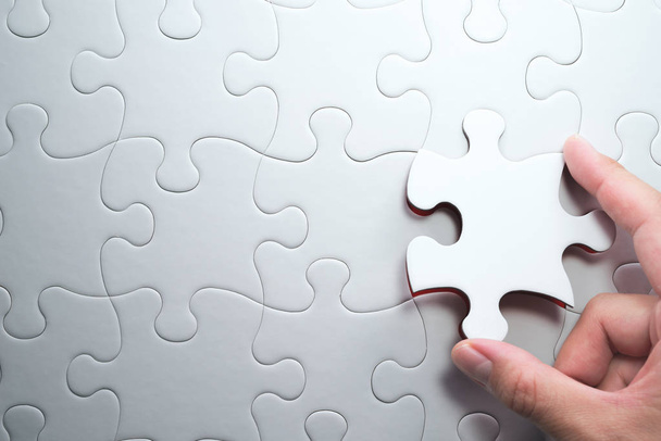 Putting last jigsaw puzzle piece. Solving and completing the task. - 写真・画像