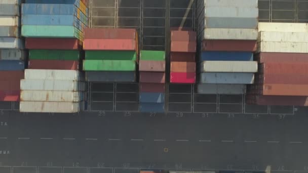 Aerial top down: merkloze Cargo containers geladen met goederen die wachten op transport in industrieel magazijn. Verzendcontainers in de haven. Stapel van veel vrachtcontainer opslag in Industrial Harbor - Video