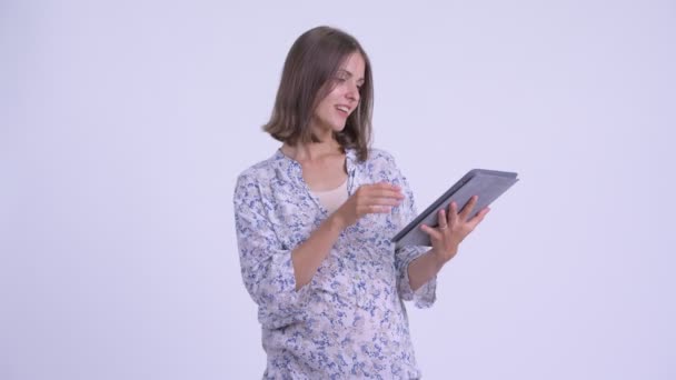 Happy young pregnant woman thinking while using digital tablet - Filmmaterial, Video