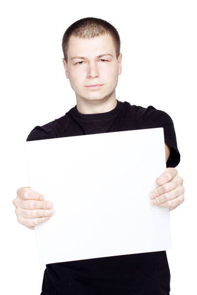Giovane uomo con un foglio bianco vuoto su sfondo bianco isolato
 - Foto, immagini