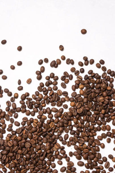 Roasted coffee beans in bulk on a light blue background. dark co - Zdjęcie, obraz