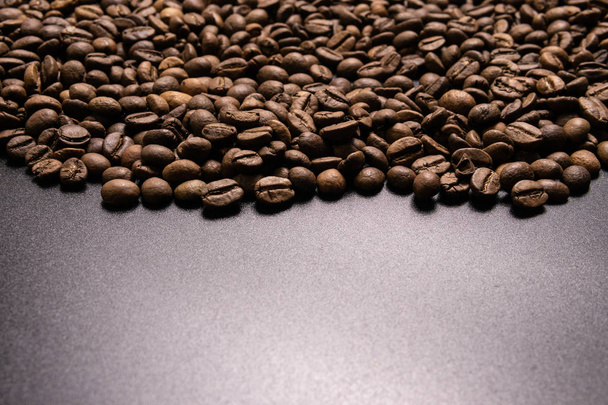 geröstete Kaffeebohnen in großen Mengen auf schwarzem Hintergrund. dunkel cofee r - Foto, Bild
