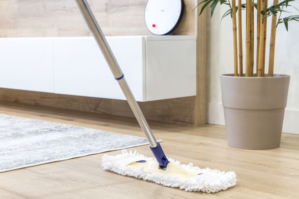 Ξύλινο πάτωμα με λευκή σφουγγαρίστρα, ιδέα υπηρεσίας καθαρισμού - Φωτογραφία, εικόνα