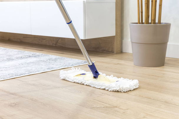 Drewniana podłoga z białym mopem, koncepcja usługi sprzątania - Zdjęcie, obraz