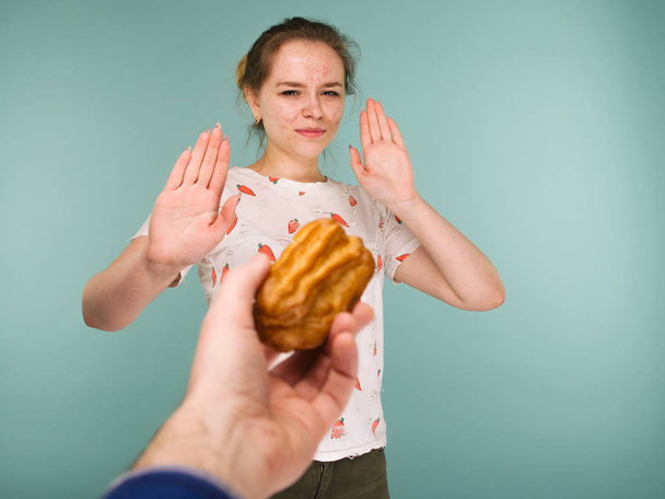 Muotokuva näppylä teini tyttö osoittaa kädet pysähtyä herkullinen kakku
 - Valokuva, kuva