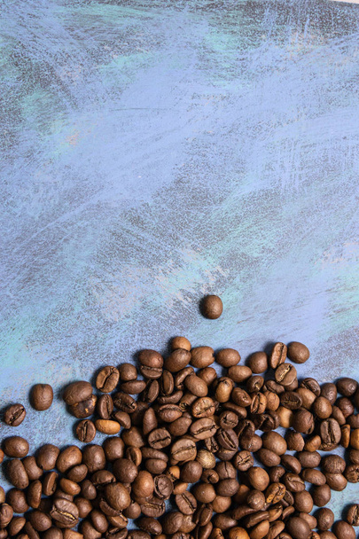 Granos de café asados a granel sobre un fondo azul. cofee oscuro ro
 - Foto, Imagen