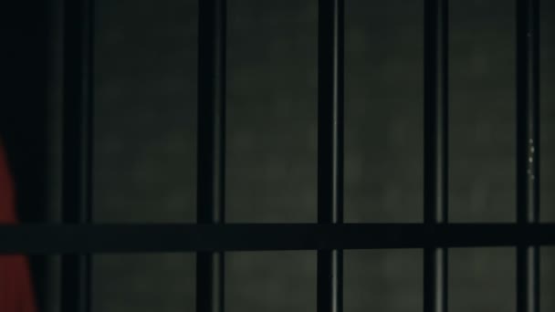 Pomoc słowo napisane na palce więźnia, mężczyzna trzyma więzienia barów, złe traktowanie - Materiał filmowy, wideo