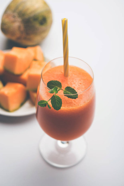 Succo di melone muschiato con fetta, noto anche come estratto di frutta Kharbuj / kharbuja, servito in un bicchiere con menta. focus selettivo
 - Foto, immagini