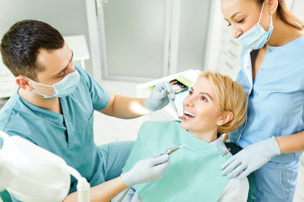 Dentist treats the teeth of the patient girl - Foto, imagen