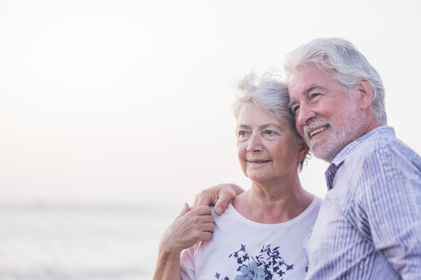 felice coppia anziana sulla spiaggia di ciottoli ridere e scherzare abbracciandosi
 - Foto, immagini