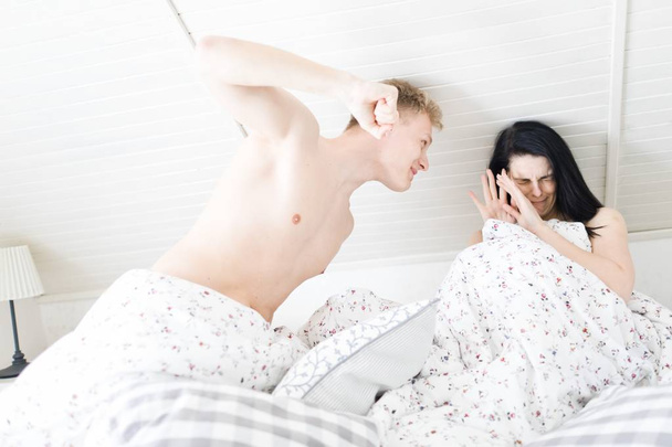 Husband going to hit wife with fist in the bedroom. - Fotografie, Obrázek