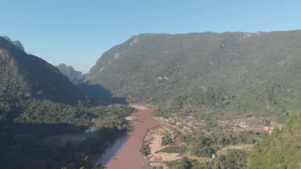 Aerial: flying over Nam Ou River Nong Khiaw Muang Ngoi Laos, sunset dramatic sky, scenic mountain landscape, famous travel destination in South East Asia. Native cinelike D-log color profile. - Footage, Video
