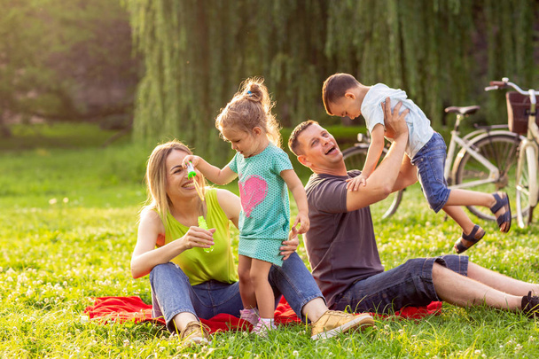 Família jovem com crianças se divertindo na natureza
 - Foto, Imagem