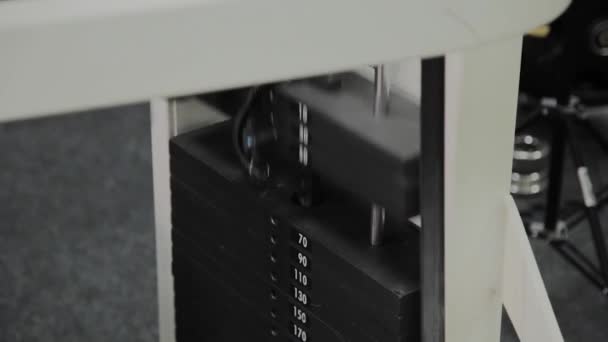 Placas de close-up empilhadas de máquina de peso com quilograma e libra no ginásio de fitness. Close-up de uma placa com um peso em movimento durante um treino em um simulador moderno. Equipamento de ginástica
 - Filmagem, Vídeo