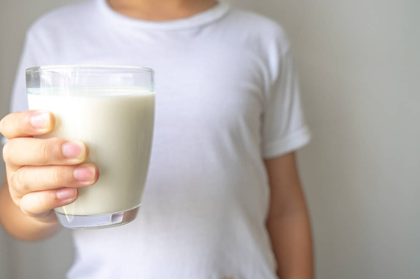 Niño sosteniendo vaso de leche para beber
 - Foto, imagen