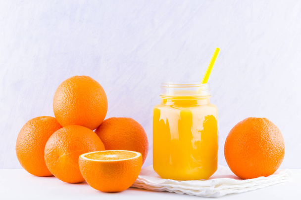 Orange fruits and juice on white background. Citrus fruit for making juice with manual juicer. Oranges on white napkin. Mason jar with orange juice - 写真・画像