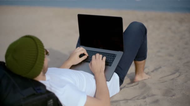 Χιλιαματικά δουλεύει σε φορητό υπολογιστή στην παραλία - Πλάνα, βίντεο