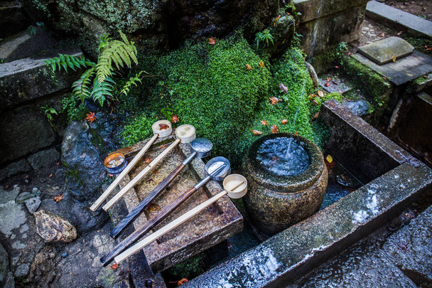 Очищающий фонтан под названием chozuya, где вы очищаете себя, очищая свое тело и ум перед посещением святилища
. - Фото, изображение