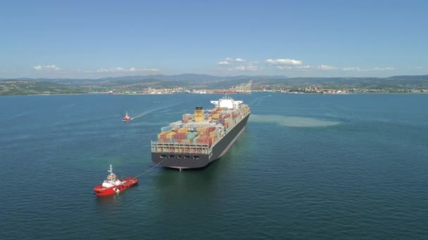 AERIAL: Fully loaded container ship coming into international ocean port. Cargo ship bringing containers filled with goods into industrial harbor. Freight ship transporting containers. Sea logistics - Footage, Video