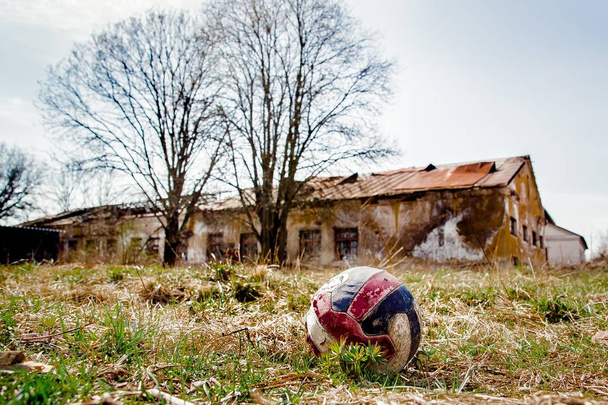 χτυπημένη μπάλα με εγκαταλελειμμένο κτίριο στο παρασκήνιο - Φωτογραφία, εικόνα