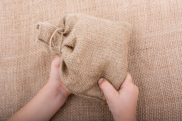 Hand met lege kleine zak gemaakt van linnen - Foto, afbeelding