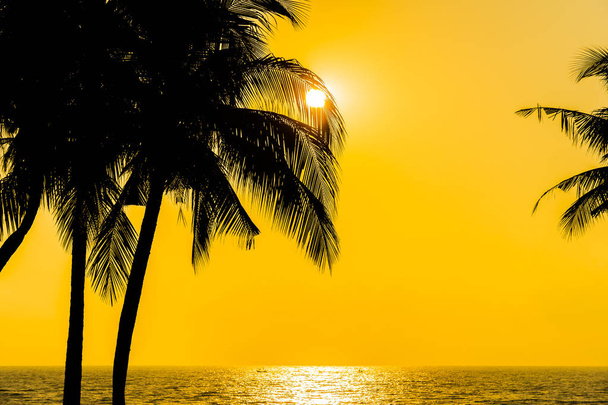 Όμορφη σιλουέτα καρύδας φοίνικα στον ουρανό neary θάλασσα ωκεάνια παραλία στο ηλιοβασίλεμα ή sunrise χρόνο για αναψυχή, ταξίδια και διακοπές έννοια - Φωτογραφία, εικόνα
