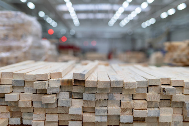 A pile of boards in a carpentry shop. Wood prepared for production in an industrial plant. Light background. - Photo, Image