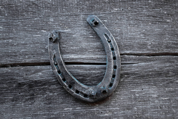 Old horseshoe on an old wooden board. The concept of luck, luck, luck. - Φωτογραφία, εικόνα