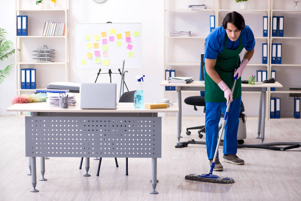 Male handsome professional cleaner working in the office  - Photo, Image