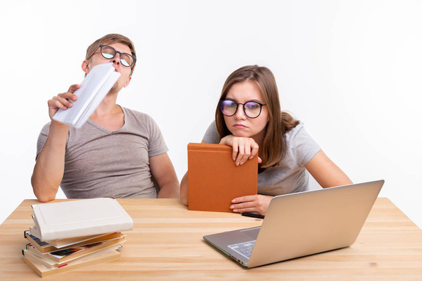 Εκπαίδευσης και έννοια-ένα ζευγάρι των νέων σε γυαλιά μοιάζουν βαριούνται μάθησης εργασία - Φωτογραφία, εικόνα