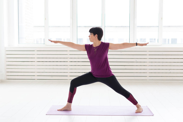 Jóga, lidé koncept - středního věku-žena dělá jógu a snažit se udělat asana - Fotografie, Obrázek