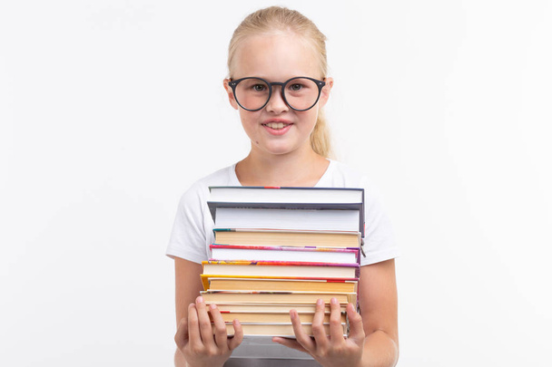 Eğitim, insanlar, çocuklar ve okul kavramı - okul öğrenci tutan gözlük içinde elinde beyaz zemin üzerine kitaplar - Fotoğraf, Görsel