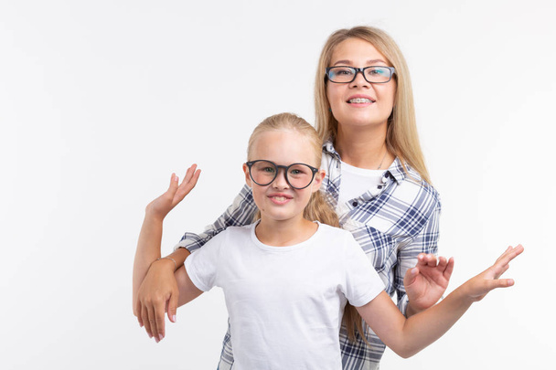 Portrait of mother and daughter with eyeglasses on white background - Photo, Image