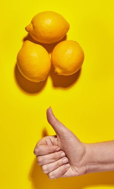 Lemon with thumbs up (Like) on yellow background. Flat lay, top view, copy space . Food concept. - Photo, Image