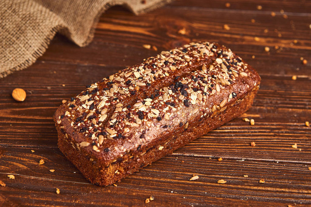 Whole wheat craft bread on wooden background. The concept of healthy food and traditional bakery. Rustic - 写真・画像