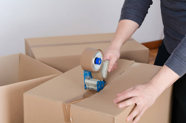 Man sealing a shipping cardboard box - Photo, Image
