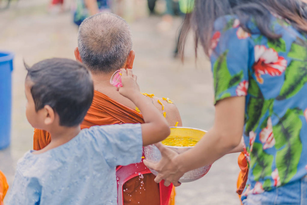 Mensen gieten van water naar boeddhistische monnik en geeft zegen - Foto, afbeelding