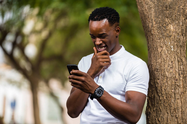 Outdoor portrait of a Young black African American men texting   - Fotoğraf, Görsel