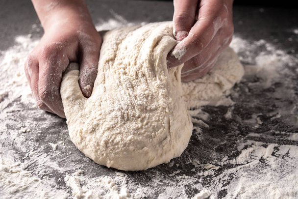 Hacer masa con las manos femeninas en la panadería
 - Foto, imagen