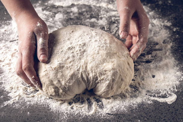 Hacer masa con las manos femeninas en la panadería
 - Foto, Imagen