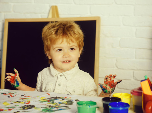 Kleine kunstenaar. Een kind met kleurrijke handen. Kunst therapie voor kinderen. - Foto, afbeelding