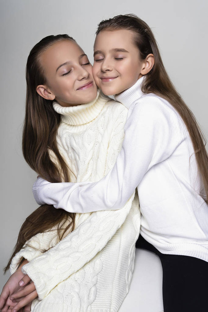 Twee schattige tiener vriendinnen schoolmeisjes dragen witte turtlenec - Foto, afbeelding