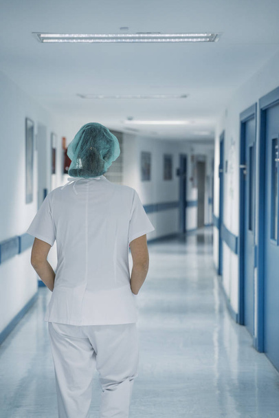 Female doctor in uniform, walking in the corridor of hospital - Fotoğraf, Görsel