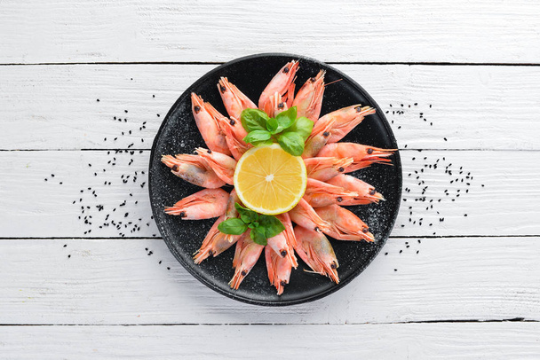Raw shrimp with lemon on the plate on a white background Wooden. Top view. Free copy space - Photo, Image