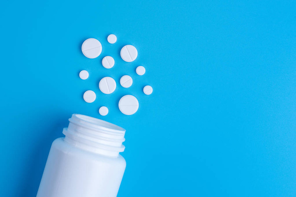 Medicina pillole o compresse bianche cadono dal flacone bianco su
  - Foto, immagini