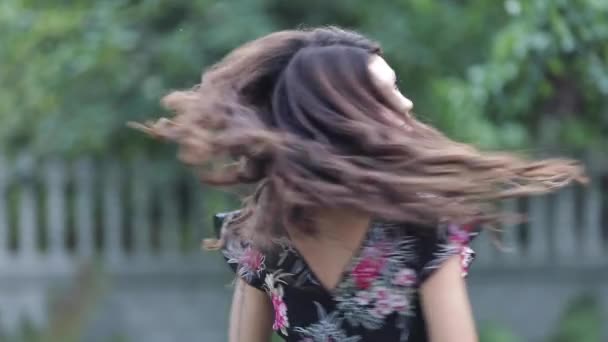 Dětská holčička v květinové šatně se směje a proplétvá se kolem - Záběry, video