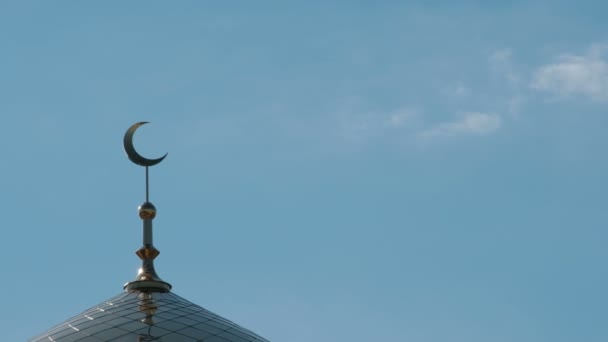 Cupola dorata della moschea con mezzaluna. Simbolo musulmano. Le nuvole nel cielo blu si muovono oltre il minareto da destra a sinistra. Islam. Ramadan
. - Filmati, video